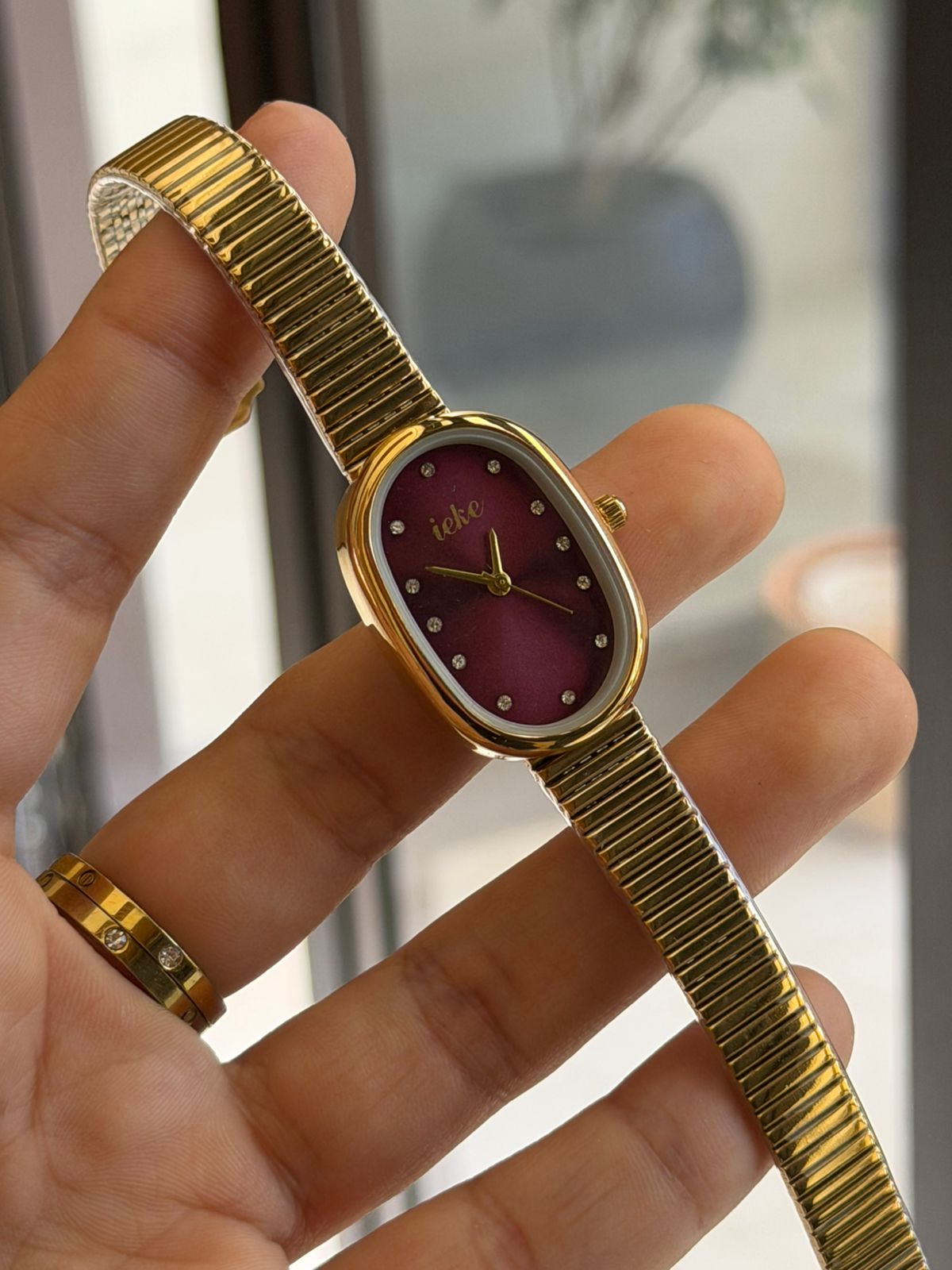 Montre femme dorée – Cadran bordeaux avec détails brillants