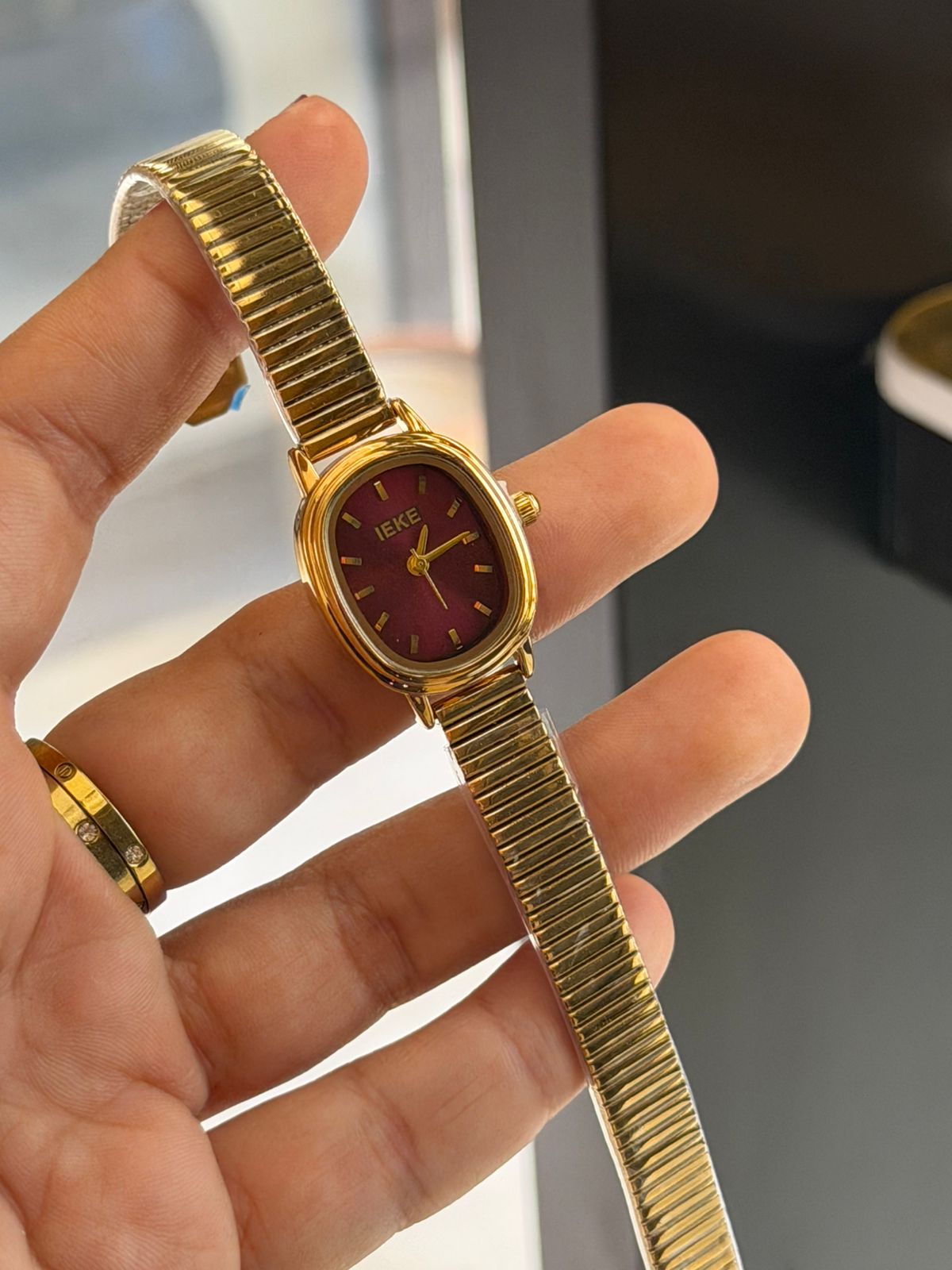Montre IEKE dorée à cadran rouge bordeaux – Élégance, brillance et détails raffinés
